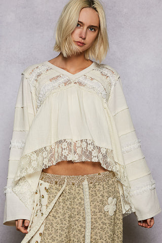 Light blue long-sleeve top with ruffle trim and lace detailing
