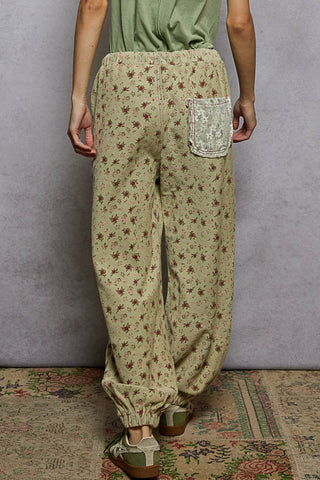 Sage green jogger pants with a floral patchwork design and a relaxed fit