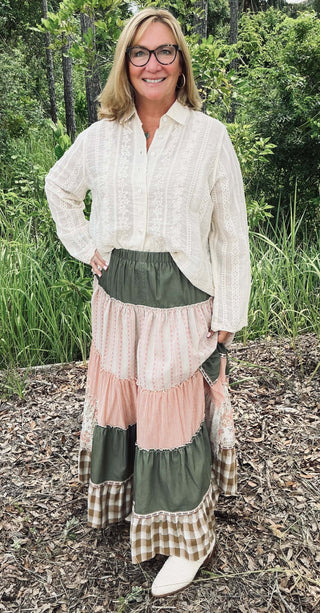 Olive Patchwork Tiered Ruffle Maxi Skirt by Easel on a hanger, showcasing its flowy, bohemian design and vibrant colors.