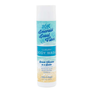 AMI Emerald Coast Luxury Body Wash (8.3 Fl. Oz) - Elegant bottle design with lush green accents against a serene beach backdrop.
