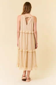 Alt text: "Elegant cream halter ruffle maxi dress with flowing silhouette on mannequin perfect for summer events.