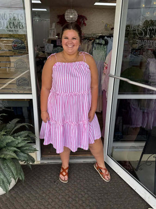 Model wearing a stylish pink striped tie shoulder tiered dress, perfect for a breezy summer look.