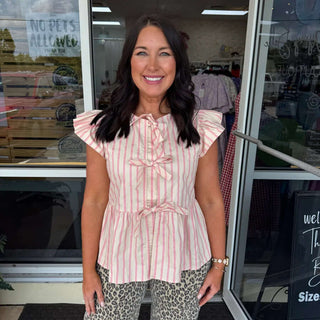 Model wearing Pink Stripe Tie Front Peplum Top by Oddi, highlighting its stylish design and flattering fit.