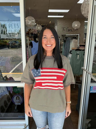 Charcoal top by Oddi with Americana flag applique, highlighting its cozy terry fabric. Final sale item, stylish and patriotic.