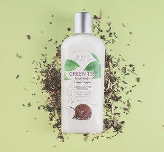 Bottle of FHF Green Tea Milk Wash with natural ingredients, featuring an elegant design, set against a light green background.