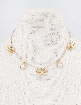 Elegant gold chain necklace with pearl and bow charms, adjustable 16-18 inches, perfect for coquette style fashion.