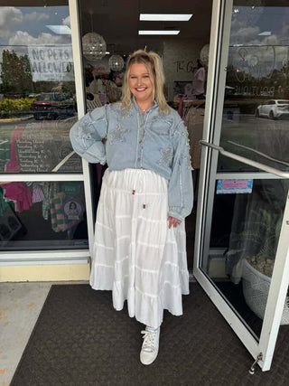 White tiered maxi skirt with drawstring waist, perfect for a boho-chic look, shown against a neutral background.