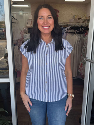 Mello White & Blue Stripe Top on hanger, showcasing elegant vertical stripes and a relaxed fit for casual, stylish wear.