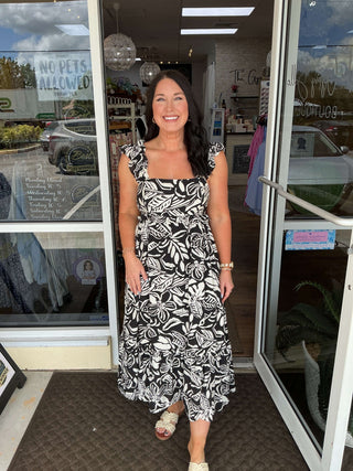 Black & Ivory Tropical Floral Ruffle Shoulder Midi Dress on mannequin, showcases chic, summer-ready style in vibrant print.