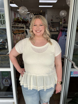 Soft washed ruffle hem wide neck top in two colors, displayed on a hanger for a stylish, casual look.