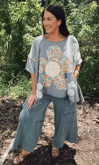 Oversized top with blue velvet, orange, ivory lace flower patchwork design on a mannequin for a trendy bohemian look.