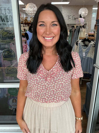 Coral floral split V-neck puff short sleeve top on hanger showcasing vibrant design and stylish silhouette.