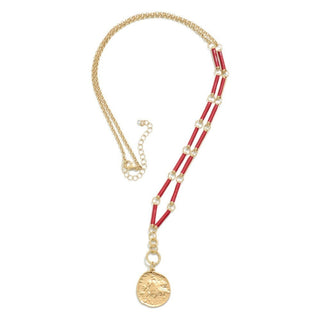 Elegant long red chain link necklace with unique pendant on display against a blurred nature background.