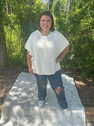 Light gray short sleeve poncho sweater with crochet accents and side ties