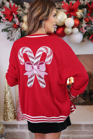 Relaxed red cardigan with a candy cane pattern and open front design