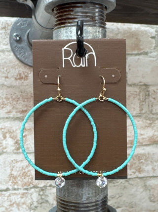 Turquoise mint hoop drop earrings with rhinestone accents on display against a white background.