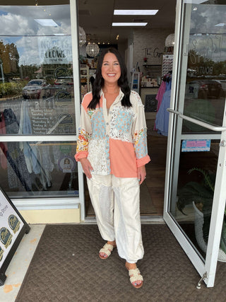POL oversized peach floral patchwork balloon sleeve shacket top with vintage style displayed on a hanger against a neutral background.