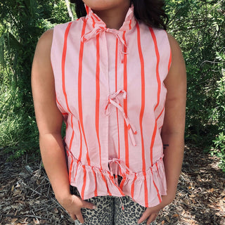 Pink & coral striped sleeveless peplum top with front tie detail, displayed on hanger against plain white background.