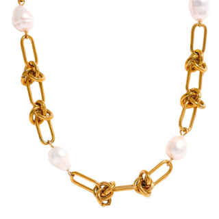 Elegant Lauren Kenzie Gold Knot and Pearl Necklace with Lifetime Warranty on a marble slab showing its classic design.