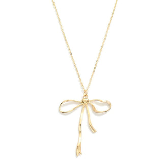 Elegant gold bow pendant necklace on delicate chain, sparkling in soft light, perfect for adding a touch of sophistication.