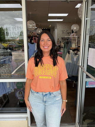 Trendy unisex "Sunshine State of Mind" tee top in soft beige with vibrant retro sun graphic, perfect for casual fashion lovers.