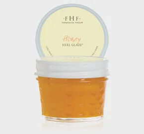 FHF Honey Heel Glaze in a rustic glass jar with wooden lid, surrounded by honeycomb and flowers for natural foot care.