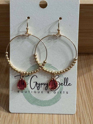 Vibrant hot pink teardrop hoop earrings with gold beads, perfect for adding a pop of color to any outfit.