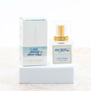 AMI Emerald Coast Mixologie Parfum Spray with sleek design set against a serene, nature-inspired background.