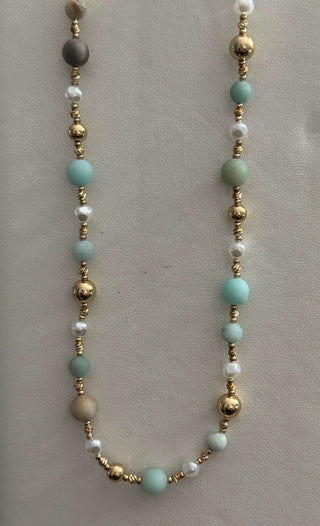 Elegant gold, pearl, and aqua mint beaded necklace on display, perfect for enhancing your style with a touch of sophistication.