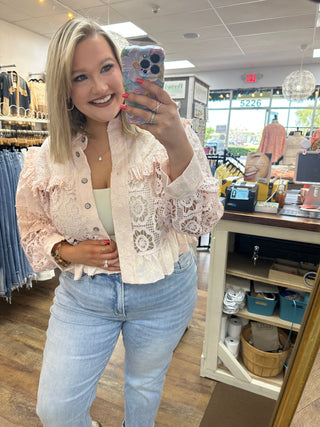 Blush pink lace button-up shacket with intricate floral cutout pattern and long sleeves.
