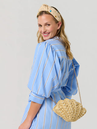 Beige woven shell-shaped crossbody tote bag with chain strap.
