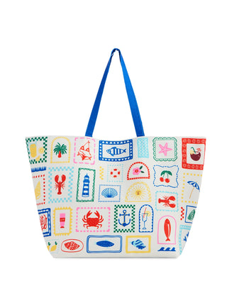 Front view of coastal patchwork tote bag showing colorful stamp prints of beach motifs including lobsters, palm trees, anchors, fish, and shells with blue handles.
