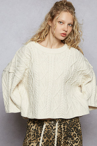 Oversized round neck cable knit sweater in soft cream, perfect for cozy layering in cooler weather