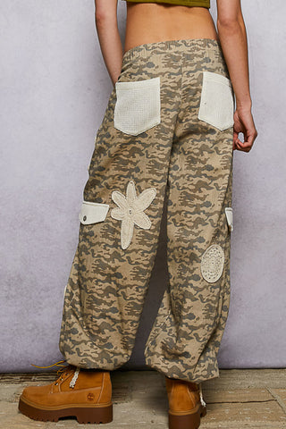 Beige camo patchwork joggers with ivory crochet patches and a relaxed fit