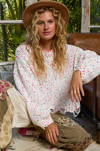 White and pink popcorn sweater with a fringed hem and relaxed fit