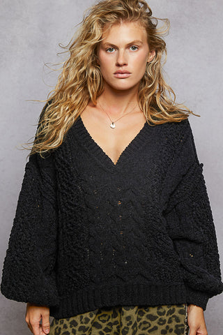 Oversized cable knit v-neck sweater in soft beige, perfect for cozy layering in cooler weather