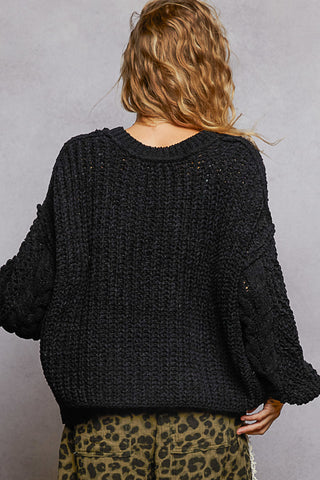 Oversized cable knit v-neck sweater in soft beige, featuring a relaxed fit and cozy texture