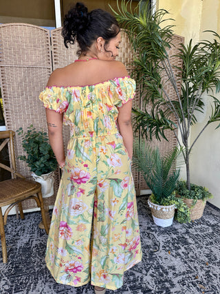 Yellow floral off-shoulder romper jumpsuit with pink and green flowers, ruched waist detail.
