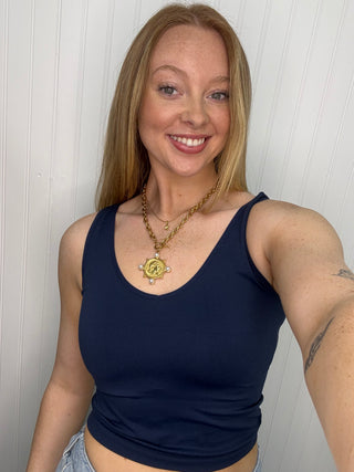 Navy sleeveless tank top with scoop neckline on model.
