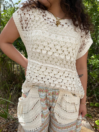 Cream crochet short-sleeve top with circular geometric pattern and scalloped lace trim.
