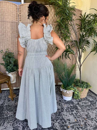 Light blue seersucker midi dress with ruffled off-shoulder sleeves and open back detail.
