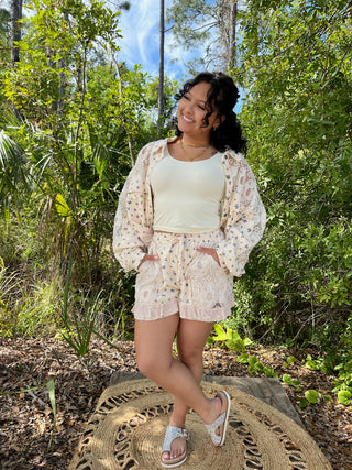 Cream lace shorts with blue floral print and matching cardigan worn with white tank top.
