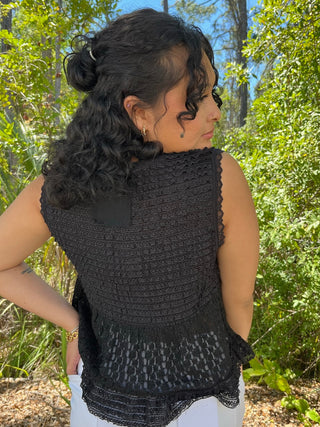 Black sleeveless V-neck top with textured knit pattern and lace trim hem.
