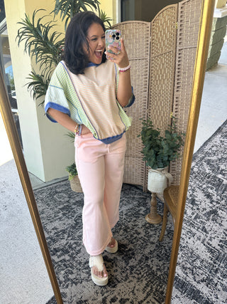 Light pink denim pants with high-waisted fit and straight leg cut.
