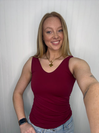 Burgundy sleeveless tank top with ruched sides and v-neckline.
