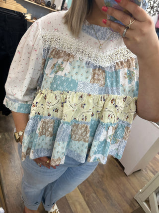 Ivory and blue tiered floral top with lace trim and patchwork design.
