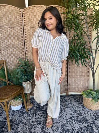 White and gray striped short-sleeve button-up shirt with collar and puffed sleeves.
