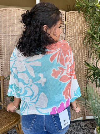Coral reef batwing top with turquoise, coral, and white abstract leaf pattern in textured knit.

