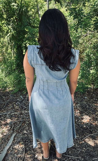 Washed light denim shirt dress with collar, pintuck‑cinched waist and button‑front closure—short sleeves and relaxed midi length