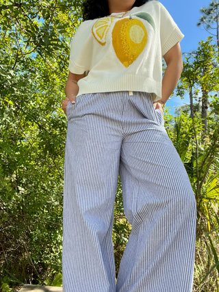 Blue and white striped wide-leg pants with elastic waist paired with cream lemon graphic knit tee.
